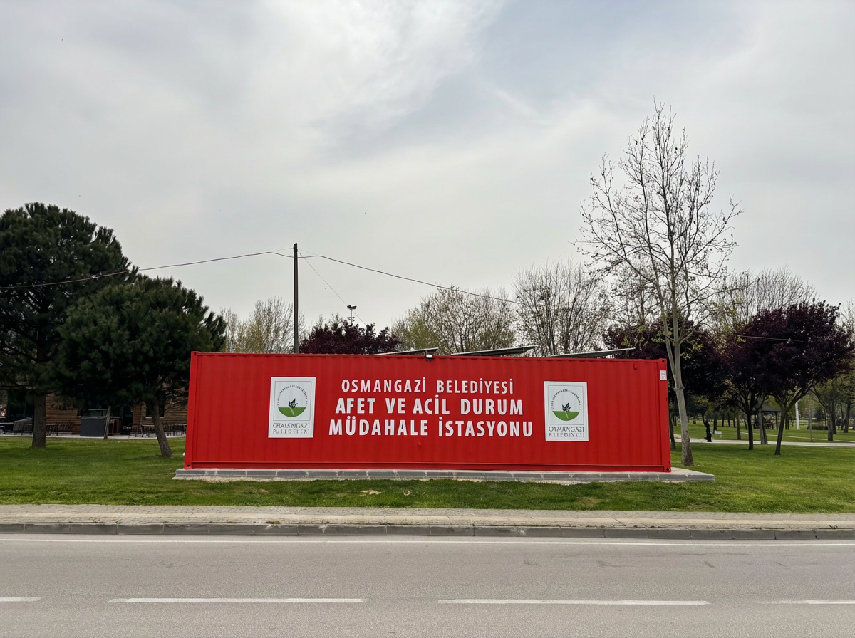 Bursa Nilüfer Hüdavendigar Parkı'nda yeşil alan içerisine konumlandırılmış, çatısında güneş panelleri olan kırmızı Osmangazi Belediyesi afet ve acil durum müdahale istasyonu.